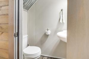 uma casa de banho branca com um WC e um lavatório em Jasper Cabin with Fire Pit, Grill and Mountain Views! em Jasper