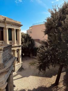 ein altes Gebäude mit einem Baum im Innenhof in der Unterkunft Palazzo Lucangeli in Porto Recanati