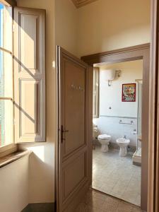 ein Bad mit einem WC, einem Fenster und einer Tür in der Unterkunft Palazzo Lucangeli in Porto Recanati