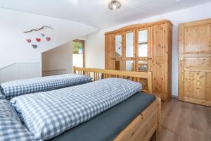 1 dormitorio con 2 camas y armario de madera en Burg-Berg-Blick, en Burgberg