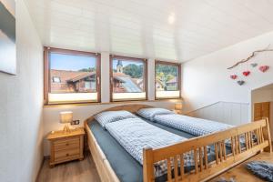 ein Schlafzimmer mit einem Bett in einem Zimmer mit Fenstern in der Unterkunft Burg-Berg-Blick in Burgberg