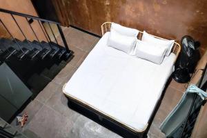 a bed with white sheets and pillows on a balcony at Earthy - Vintage in Shimoga