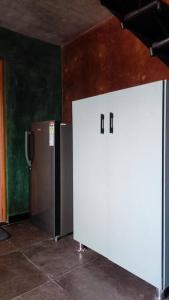 a room with two refrigerators sitting next to a wall at Earthy - Vintage in Shimoga