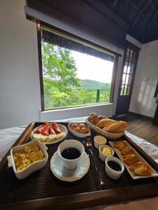 a tray of breakfast foods on a table with a window at Cinque Terre Pousada & Bistrô in Rio de Janeiro