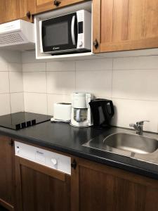 a kitchen with a sink and a microwave at Résidence Hameau De Balestas Mp - 3 Pièces pour 6 Personnes 454 in Germ