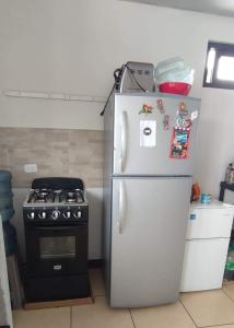a white refrigerator in a kitchen next to a stove at Private room within apartment in zone 7 in Guatemala