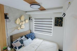 een kleine slaapkamer met een bed en een raam bij A2J Luxury 2BR Near Il Corso & SM Seaside Cebu in Cebu City