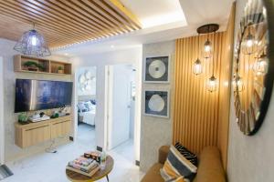 een woonkamer met een bank en een televisie bij A2J Luxury 2BR Near Il Corso & SM Seaside Cebu in Cebu City
