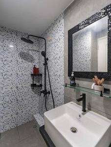 een badkamer met een wastafel, een spiegel en een douche bij A2J Luxury 2BR Near Il Corso & SM Seaside Cebu in Cebu City