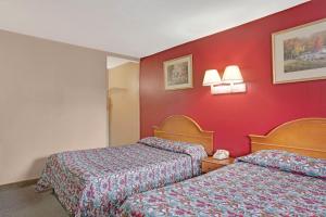 2 Betten in einem Hotelzimmer mit roten Wänden in der Unterkunft Knights Inn of Pine Brook in Pine Brook