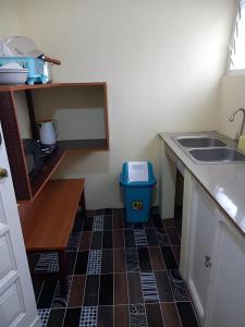 a small kitchen with a sink and a tiled floor at Lord's Hands Guesthouse Hotel in Winneba