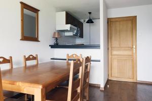 uma cozinha e sala de jantar com uma mesa de madeira e cadeiras em Résidence Hameau De Balestas Mp - 2 Pièces pour 6 Personnes 604 em Germ