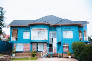 a blue house with a black roof at Nina's Apartment in Kigali
