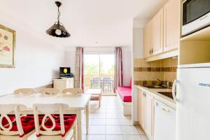 eine Küche mit einem weißen Tisch und Stühlen in einem Zimmer in der Unterkunft Les maisons Le Rouret - maeva Home - Maison 3 pièces 6 personnes - Sélection MAE-5094 in Grospierres