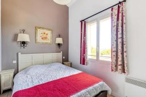 ein Schlafzimmer mit einem Bett mit einer rot-weißen Decke in der Unterkunft Les maisons Le Rouret - maeva Home - Maison 3 pièces 6 personnes - Sélection MAE-5094 in Grospierres