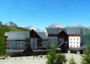 a large building with mountains in the background at Résidence Royal Peyragudes Mp - Studio pour 4 Personnes 994 in Germ