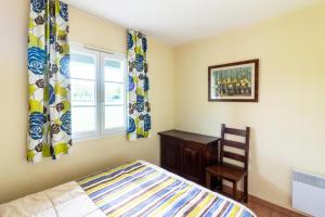 a bedroom with a bed and a chair and a window at Résidence Les Belles Rives - maeva Home - Appartement 2 pièces 5 personnes - Confort MAE-4474 in Argentat +17 photos