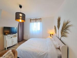 ランスにあるFaro, vue sur la Cathédraleのベッドとテレビのある白い寝室