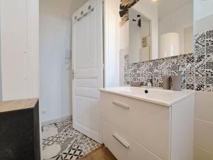 ランスにあるFaro, vue sur la Cathédraleの洗面台と鏡のある白いバスルーム