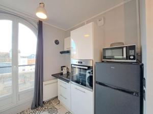 ランスにあるFaro, vue sur la Cathédraleの黒い冷蔵庫と電子レンジのあるキッチン +19枚の写真