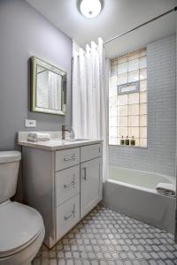 La salle de bains est pourvue de toilettes, d'une baignoire et d'un lavabo. dans l'établissement Spacious Ukrainian Village Retreat, à Chicago