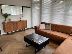 a living room with a couch and a coffee table at Luxe boshuisje Arlo in Ermelo! in Ermelo