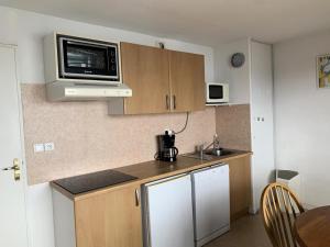 a small kitchen with a sink and a microwave at Résidence Royal Peyragudes Mp - Studio pour 4 Personnes 714 in Germ