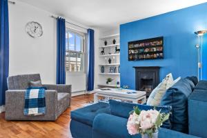a living room with blue walls and a blue couch at Blue Themed Luxury 1 Bedroom Balcony Flat, With Double Sofa Bed and Fast Wifi! Accommodates up to 6 Guests! Hyde Park! in London