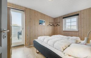 バイアス・スタンにあるNice Home In Vejers Strand With 2 Bedrooms, Sauna And Wifiの窓のある木製の壁のドミトリールームのベッド1台分です。