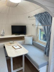 ein kleines Zimmer mit einem Sofa und einem Tisch in der Unterkunft Tiny IglooKarlsson in Belau