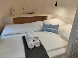 ein weißes Bett mit Handtüchern darüber in der Unterkunft Tiny IglooKarlsson in Belau