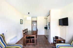 a dining room with a table and chairs and a tv at Résidence Les Belles Rives - maeva Home - Appartement 2 pièces 7 personnes 084 in Argentat