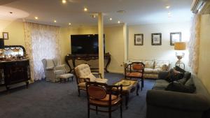 a living room with a couch and chairs and a tv at HOTEL RIAZA in Riaza