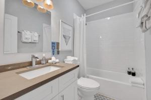 a white bathroom with a sink and a toilet at Spacious Bucktown Sanctuary in Chicago