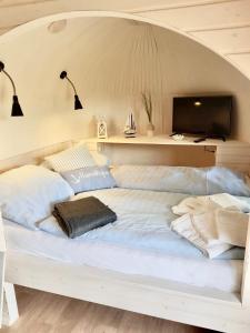 a large white bed in a room with a tv at Tiny Igloo Frodo in Belau