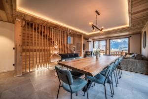 ein Esszimmer mit einem Holztisch und Stühlen in der Unterkunft Chalet Bellatrix Morzine - by EMERALD STAY in La Côte dʼArbroz + 62 Fotos