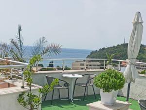 a patio with a table and chairs and an umbrella at Apartments Mitende in Budva