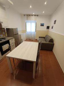 a kitchen and living room with a table and a couch at La Casetta per te in Gravina di Catania