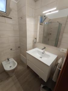a white bathroom with a sink and a toilet at La Casetta per te in Gravina di Catania