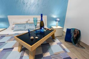 a bedroom with a bed and a table with a bottle of wine at Il Faro Casa Vacanze San Vito Lo Capo Sicilia in San Vito lo Capo