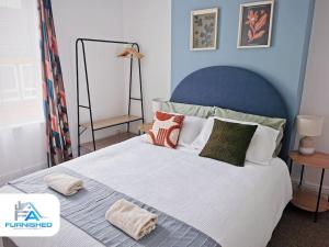 a bedroom with a large white bed with pillows at Family house - Jacuzzi - Pets in Scarborough