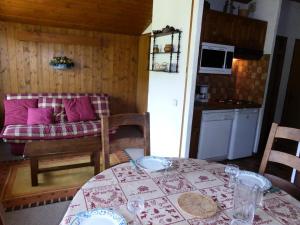 uma sala de jantar com uma mesa e uma cozinha em Résidence Princesse En Etraz Narcisse - 3 Pièces pour 6 Personnes 294 em Combloux