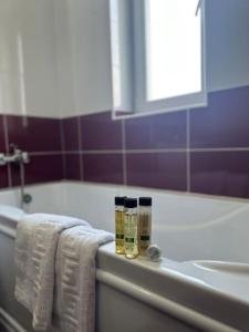 uma casa de banho com toalhas, um lavatório e uma banheira em Cozy 2 bed flat em Sînpetru