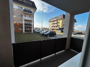 uma vista a partir de uma varanda de um parque de estacionamento com carros em Cozy 2 bed flat em Sînpetru