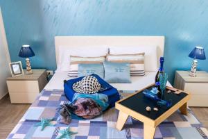 a bedroom with a white bed and a table at Il Faro Casa Vacanze San Vito Lo Capo Sicilia in San Vito lo Capo