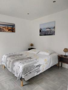 a bed in a bedroom with two pictures on the wall at Amarante des Landes 