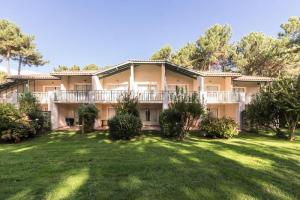 una vista exterior de una casa grande con patio en Les maisons du Domaine du Golf de Pinsolle - maeva Home - Maison 3 pièces 6 324, en Soustons