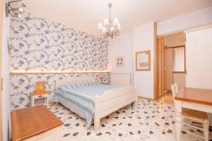 a bedroom with a bed and blue and white wallpaper at ROOMS 66 in Campobasso