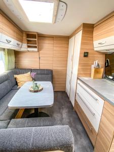 - un salon avec une table dans une caravane dans l'établissement George Glamper KÜSTENKIND, à Belau