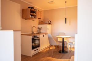 eine Küche mit einem Tisch, einem kleinen Tisch und Stühlen in der Unterkunft Hotel Seeblick in Thülsfeld